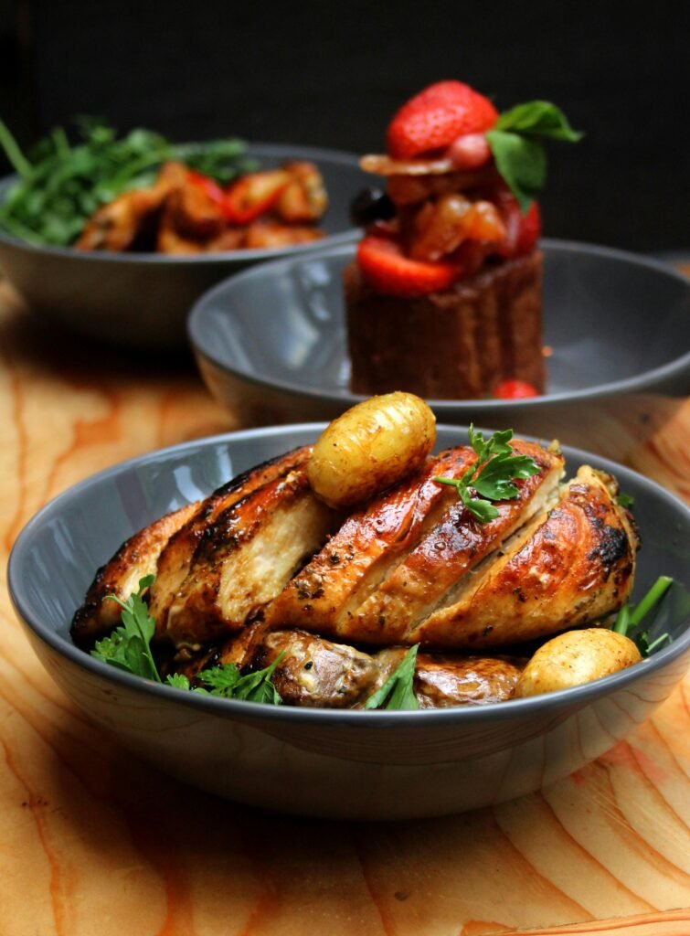 Roasted Lemony Greek Chicken & Fingerling Potatoes Delicious roasted chicken breast with potatoes and fresh salad in elegant bowls.